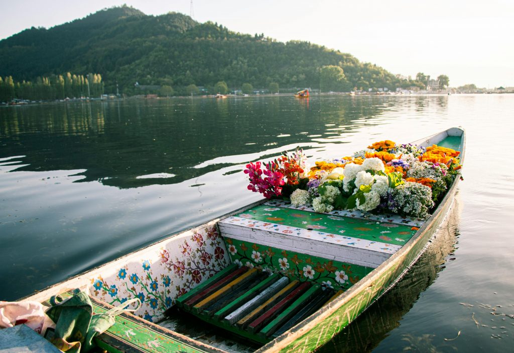 a local selling flowers to tourist visiting dal lake