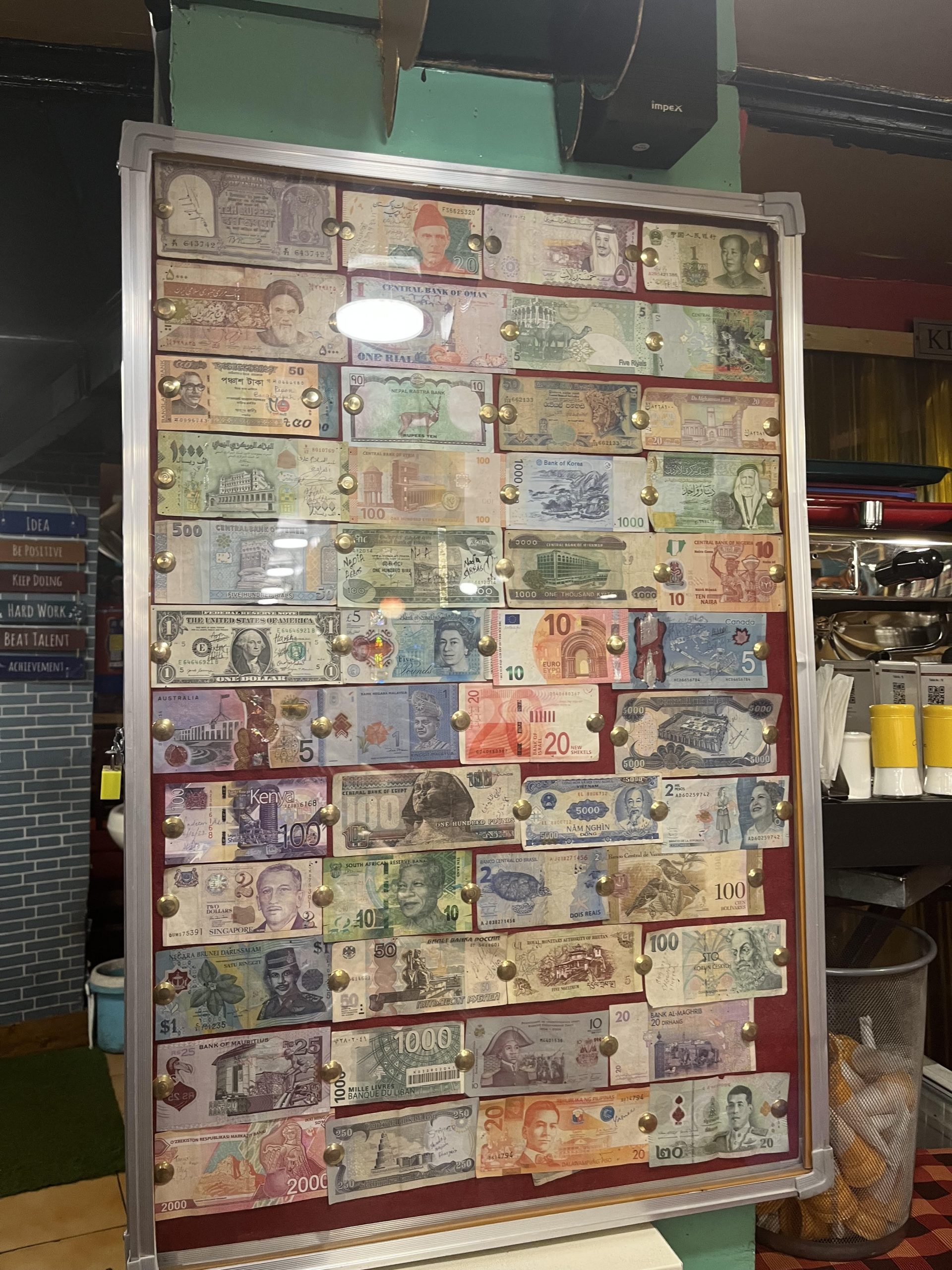 cafe owner's collection of different currencies.